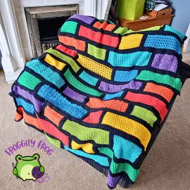 The Wall Of Stitches sampler blanket over a chair